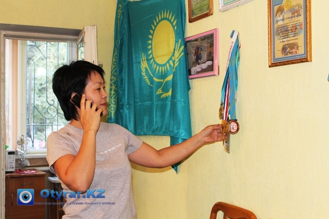 На стене все заслуженные медали, грамоты, дипломы, а так же флаг Республики, который поднимает дух, признается Аскар Клушев. На фото супруга ветерана по вольной борьбе.