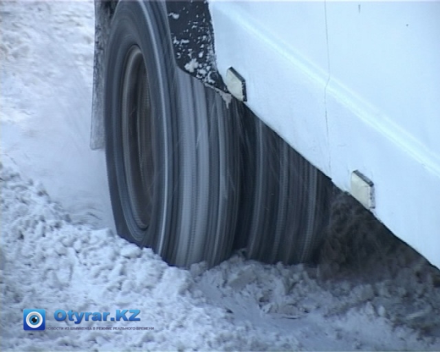 Колеса автобусов тонут в снежной жиже и скользят по находящемуся под снегом льду, не давая транспортному средству сдвинуться с места.