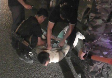 Двое спецназовцев ловко уложили нарушителя на асфальт, а руки заковали в наручники