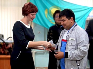 Представитель торговой сети "Изуми" вручает конверт с денежным призом победителям республиканской спартакиады