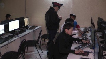 Сотрудник Енбекшинского РОВД проверяет документы посетителей компьютерного клуба