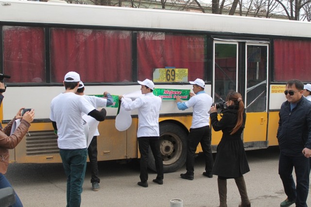 После автопробега и шествия с флагами парни и девушки украсили проезжающие автобусы праздничными наклейками 