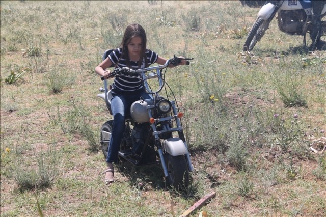 Девочка совсем недавно села на мотоцикл, но у же с легкостью управляет железным конем