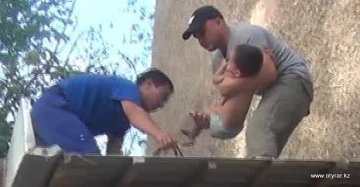 Спасательная бригада спускает малыша с крыши магазина