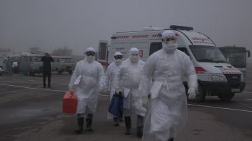 Эпидемиологи направляются к воздушному судну, где находится больной с подозрением на лихорадку Эбола