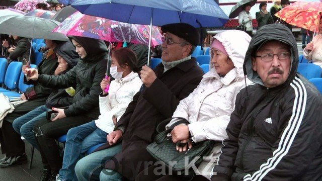 В Шымкенте отпраздновали День города. Дождь. Люди под зонтами