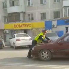 В Шымкенте задержали водителя автомобиля, который протащил на капоте машины полицейского Полицейский задерживает автомобиль