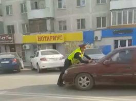 Полицейский задерживает автомобиль