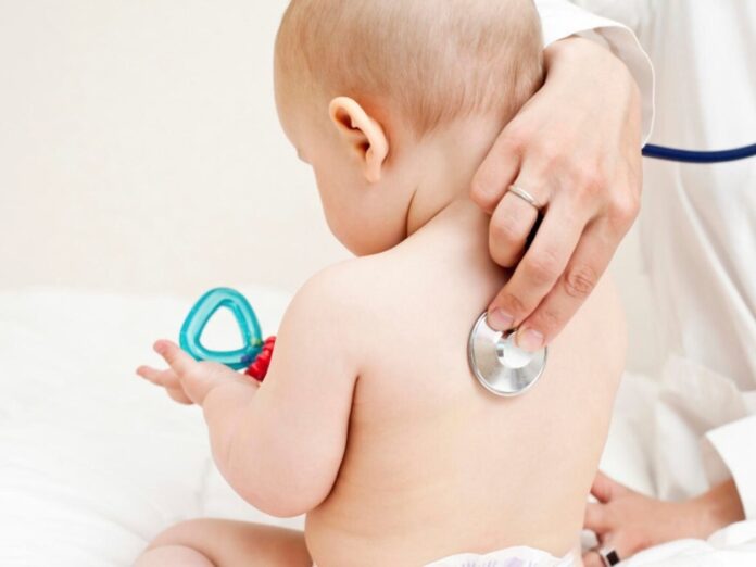 врач слушает ребенка стетоскопом