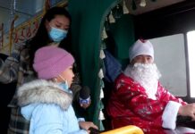 Дед Мороз за рулем автобуса развозит жителей Шымкента