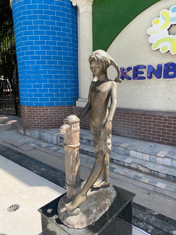 Скульптура девочки у колонки